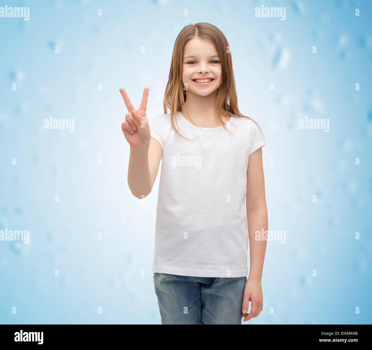 Petite fille en blanc T-shirt montrant le geste de paix Banque D'Images