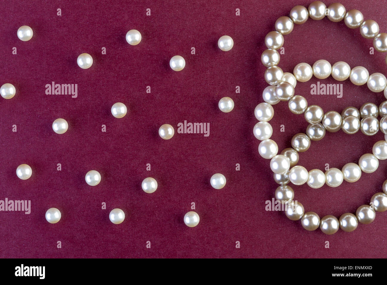 Collier perles argent et blanc sur fond rouge foncé Photo Stock - Alamy