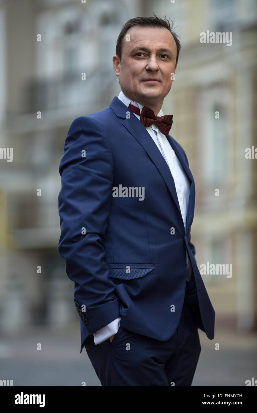 L'homme élégant dans un costume avec cravate papillon bleu Banque D'Images