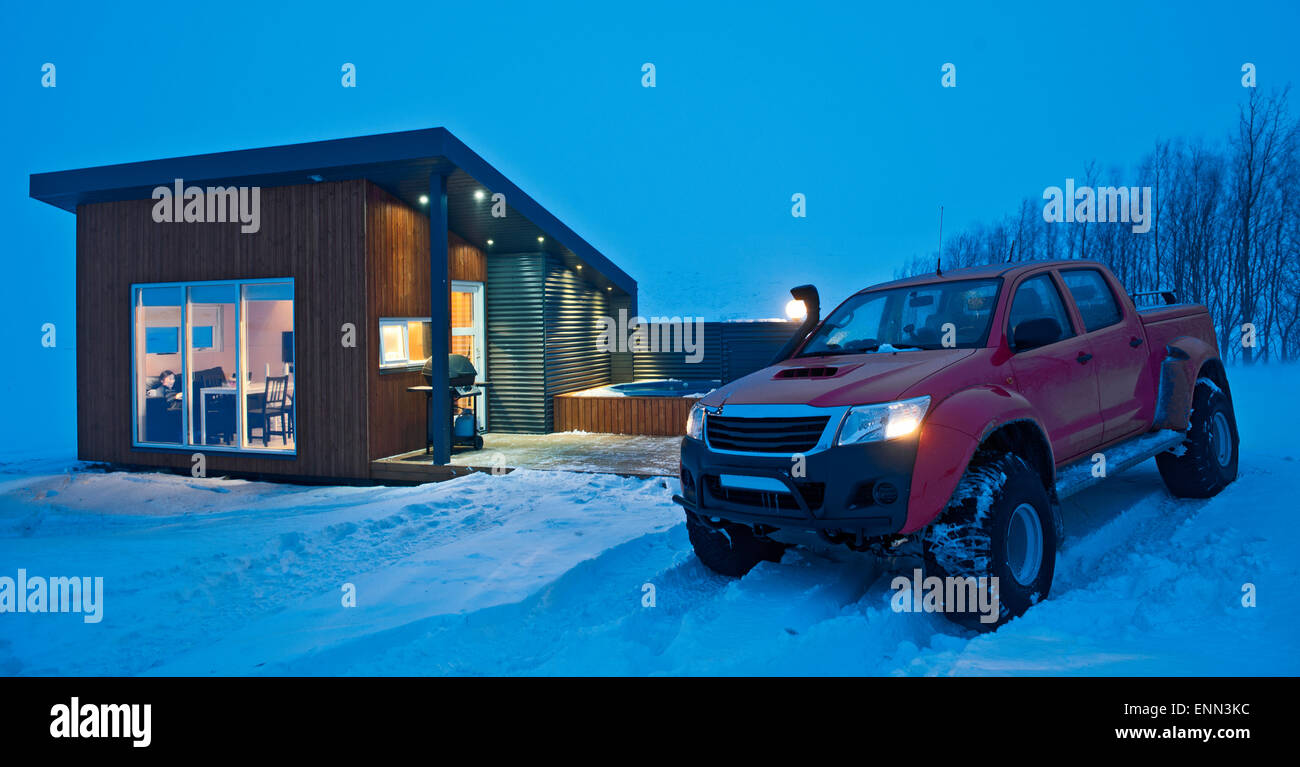 Le sur mesure 4x4 pick up truck garé à l'extérieur d'un chalet en hiver dans le nord de l'Islande à Laugar, pendant une tempête Banque D'Images