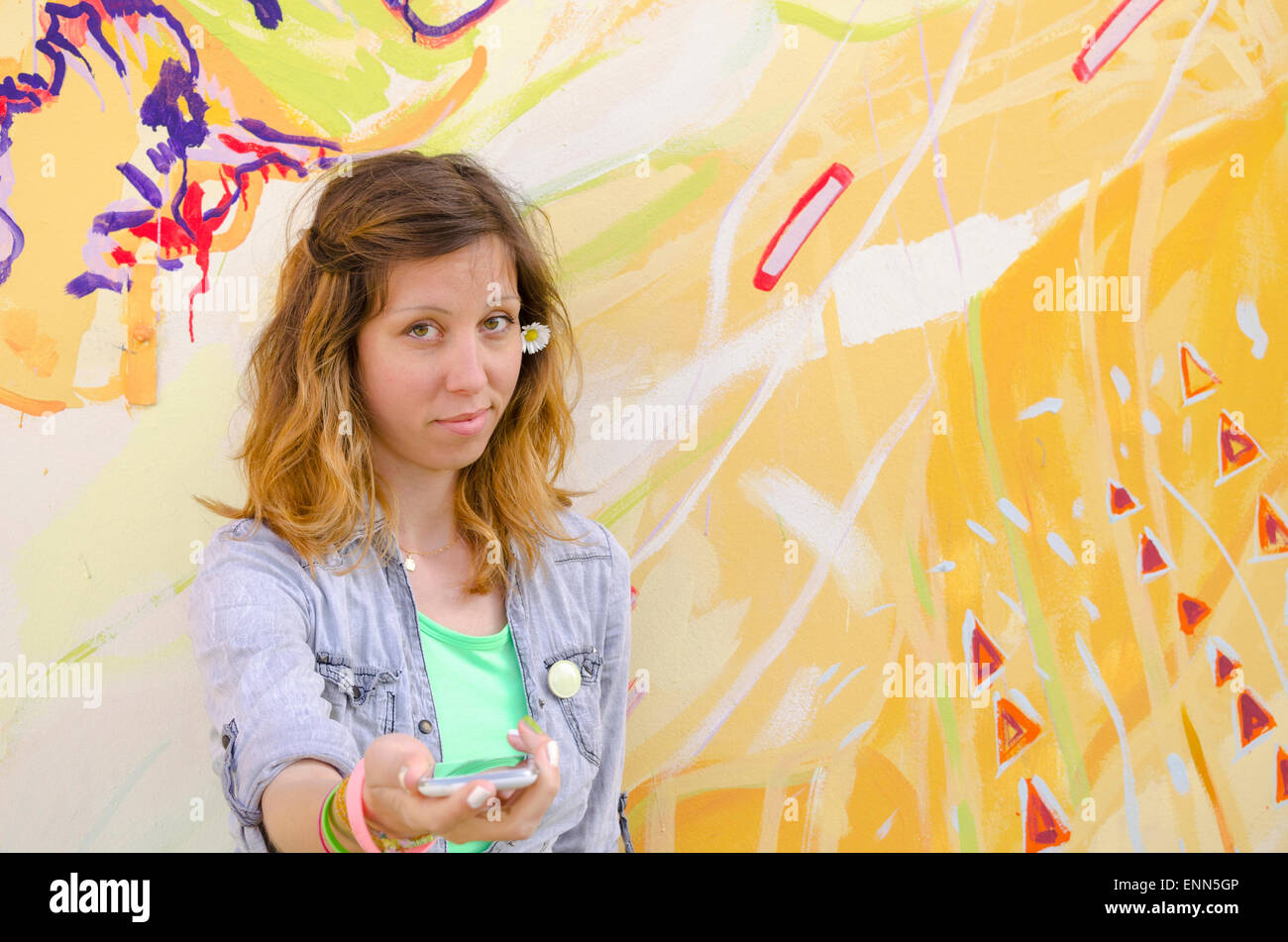 Brunette girl posing contre un fond coloré holding daisies Banque D'Images