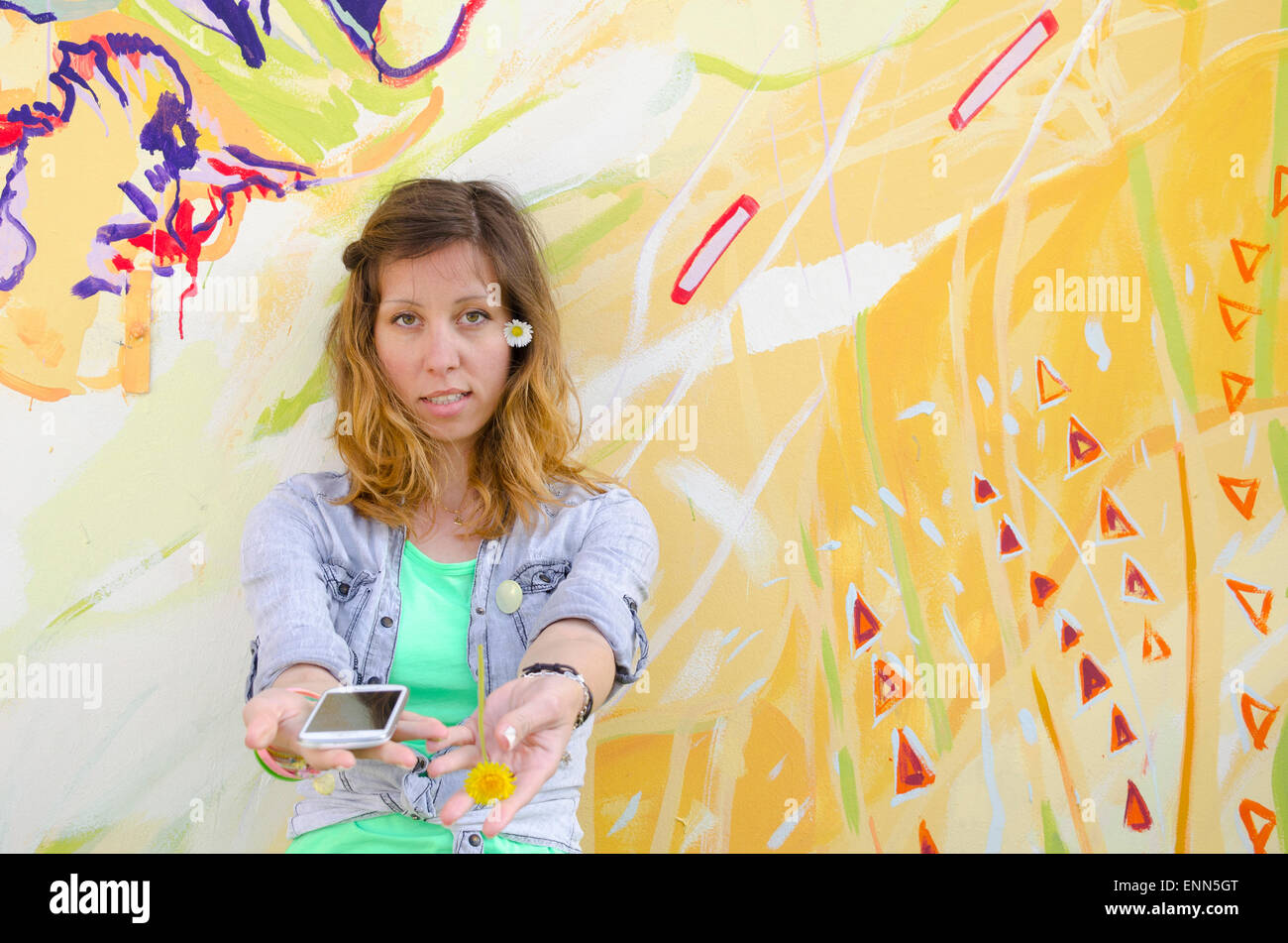 Brunette girl posing contre un fond coloré holding daisies Banque D'Images