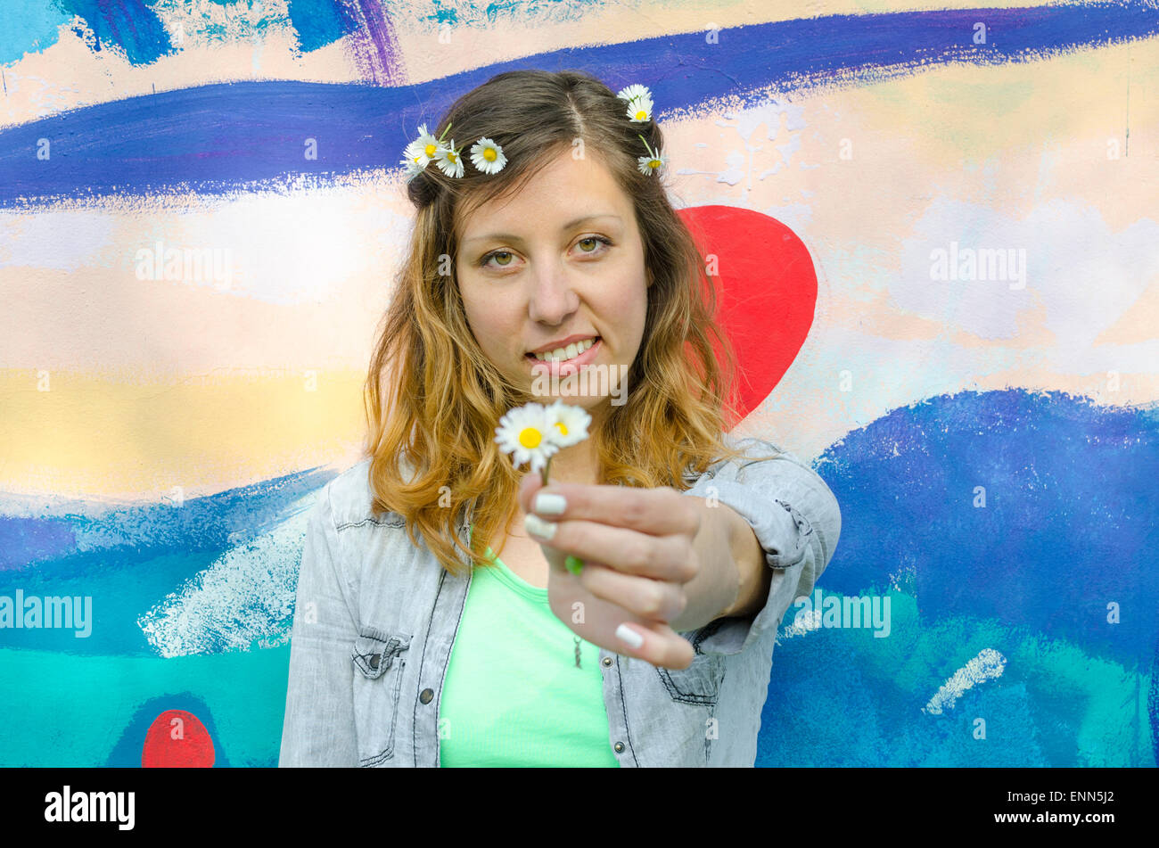 Brunette girl posing contre un fond coloré holding daisies Banque D'Images