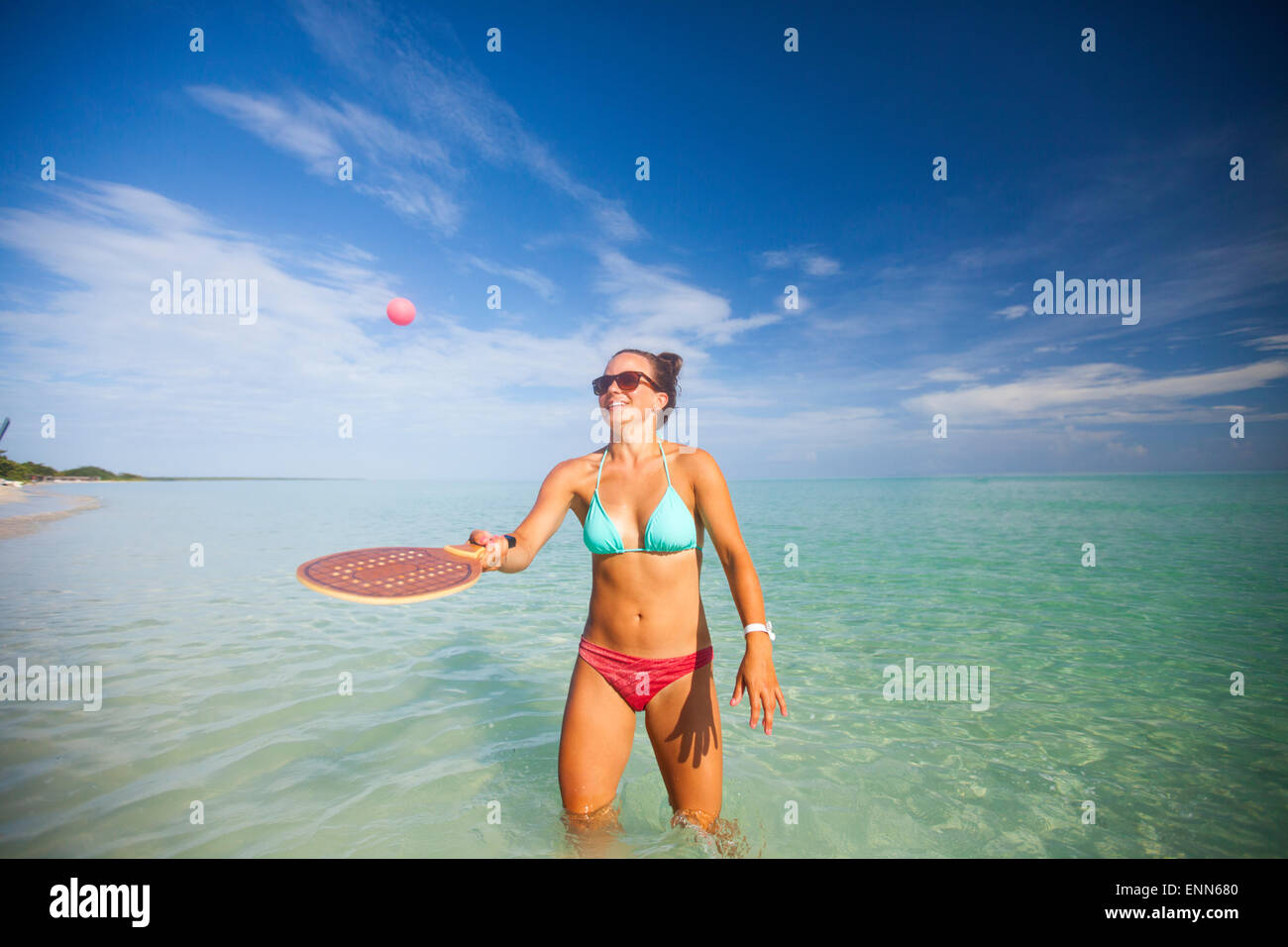 Une jeune femme joue racquetball sur la plage. Banque D'Images