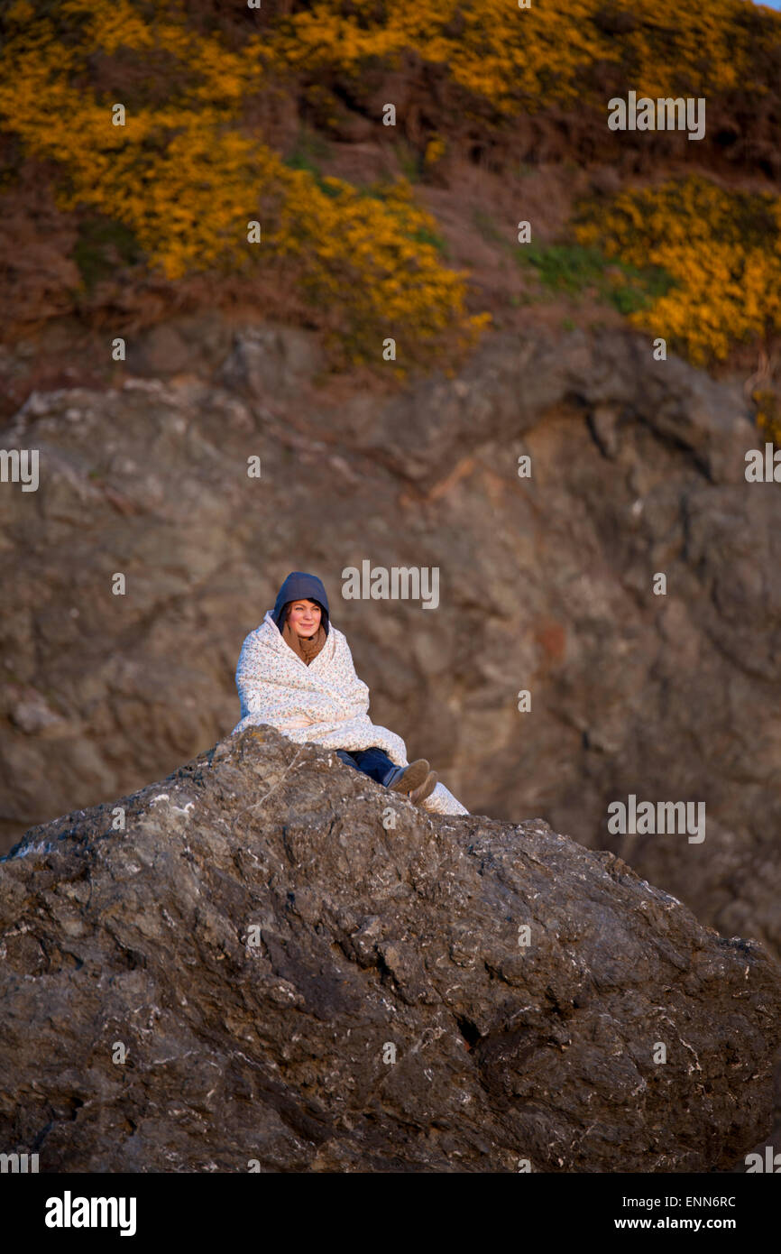 Une jeune femme composée sur un rocher promontoire de Bandon Bay, Oregon. Banque D'Images