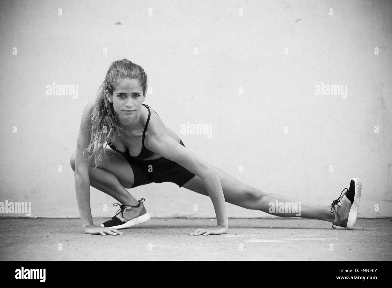 Modèle de remise en forme Maria Ambrose étend sa jambe sur un terrain de handball à Brooklyn, New York. Banque D'Images