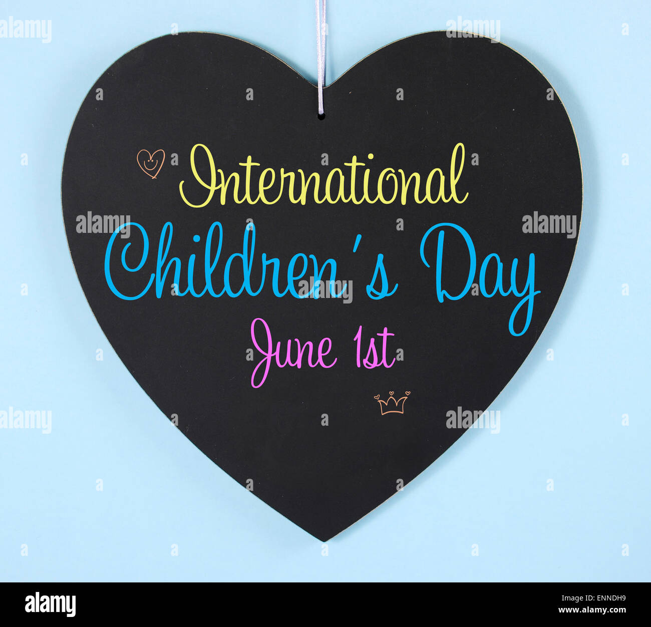 Le message d'accueil de jour pour enfants international sur tableau noir en forme de coeur signe sur fond bleu pâle. Banque D'Images