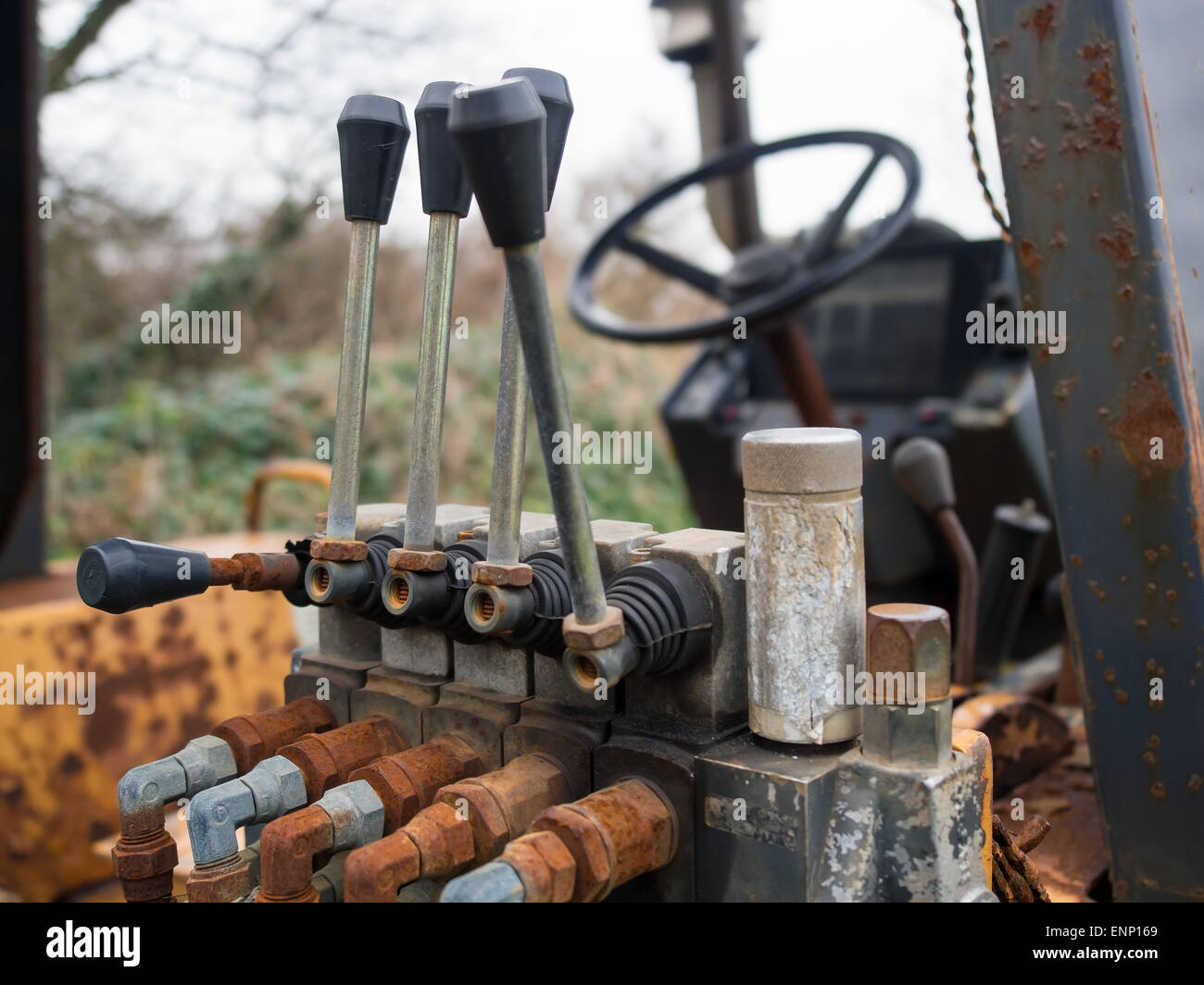 Rusty soupapes hydrauliques et leviers dans la cabine d'un vieux tracteur. Banque D'Images