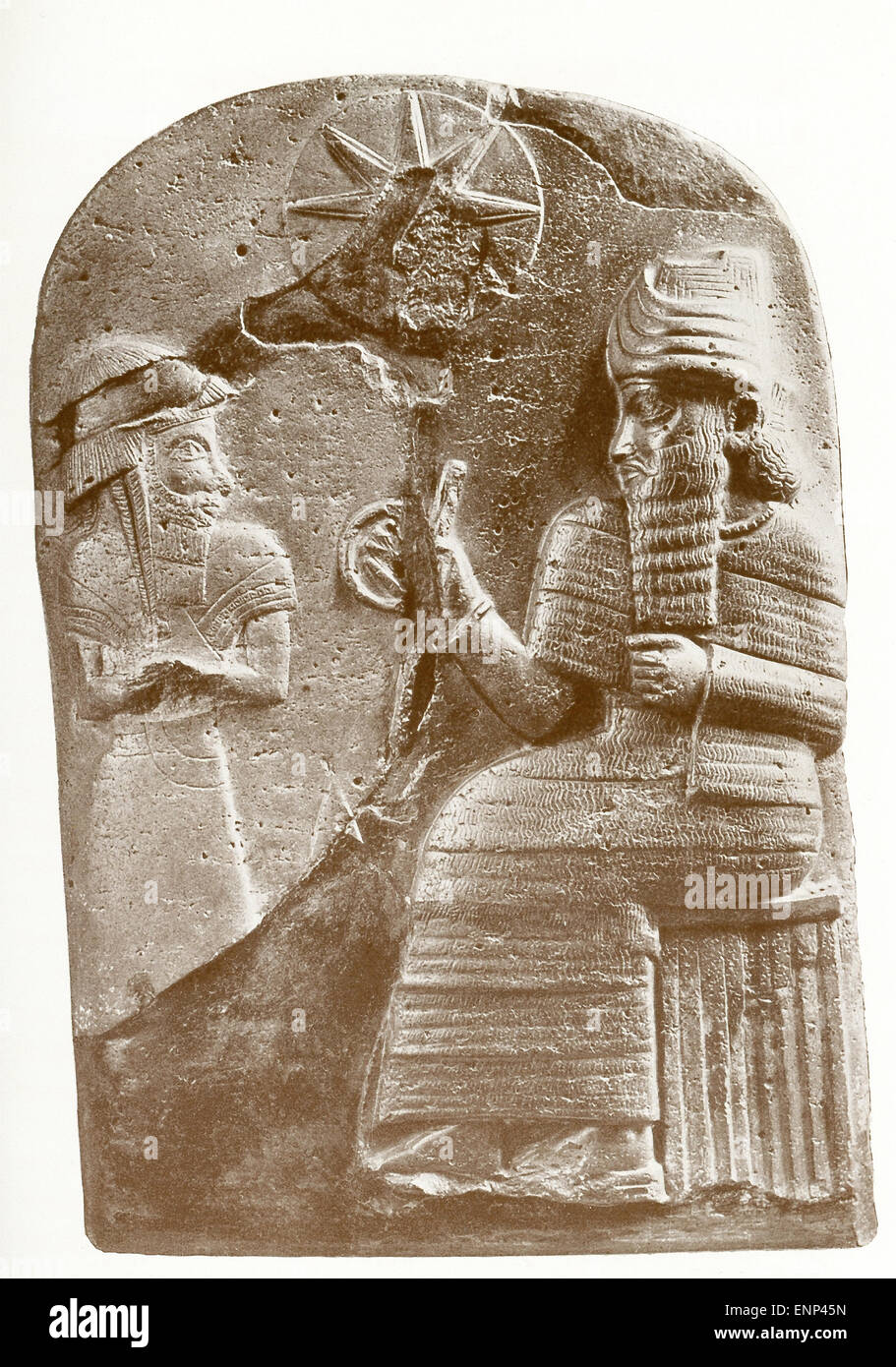 La figure sculptée à gauche s'Hammourabi, debout devant Shamash, le dieu soleil et "Seigneur de jugement." Le disque au-dessus et entre les deux chiffres représente un disque solaire. Hammourabi est un roi de Babylone de 1792 à 1750 avant J.-C. et est connu pour l'ensemble de lois appelé le Code d'Hammourabi, l'un des premiers codes de lois écrites, qui ont été inscrits au-dessous d'une scène similaire sur une stèle de diorite noire qui mesurait plus de 8 pieds de hauteur. Banque D'Images