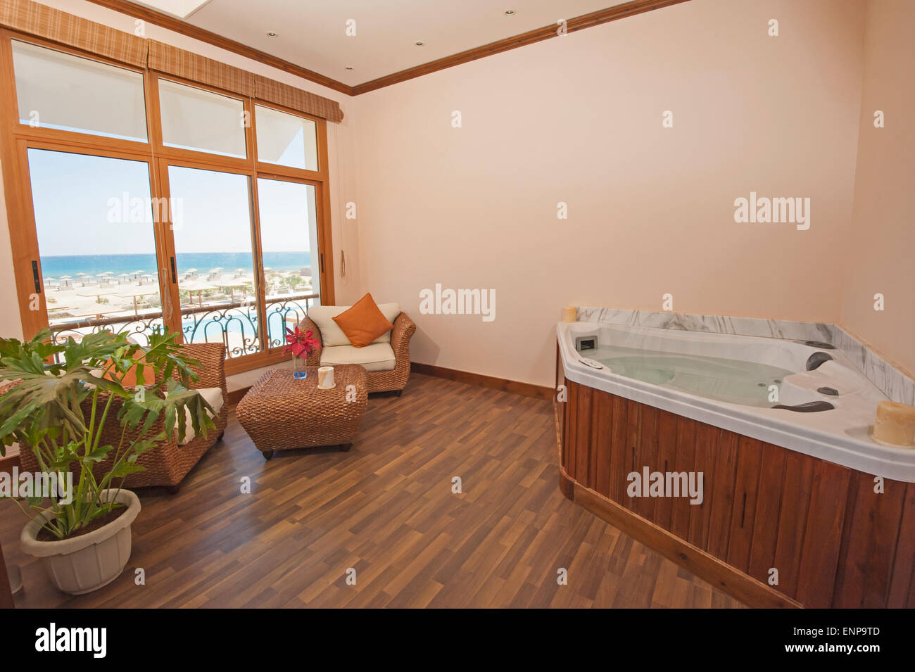 Jacuzzi dans la chambre privée de spa luxueux, avec des chaises et vue sur la mer Banque D'Images