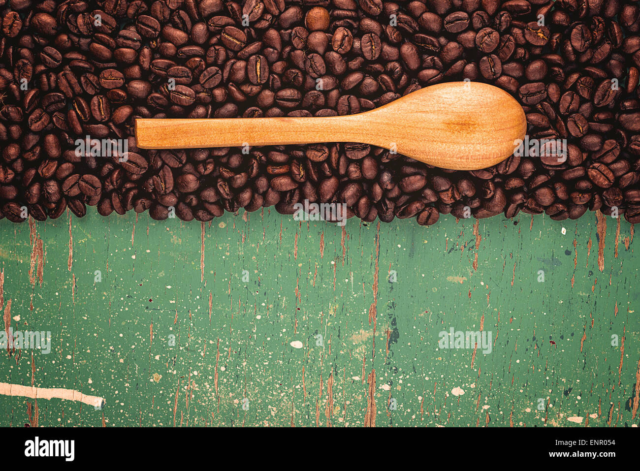 Les grains de café Roasted Brown et cuillère en bois rustique sur la planche en bois Grunge Background Conseil Banque D'Images