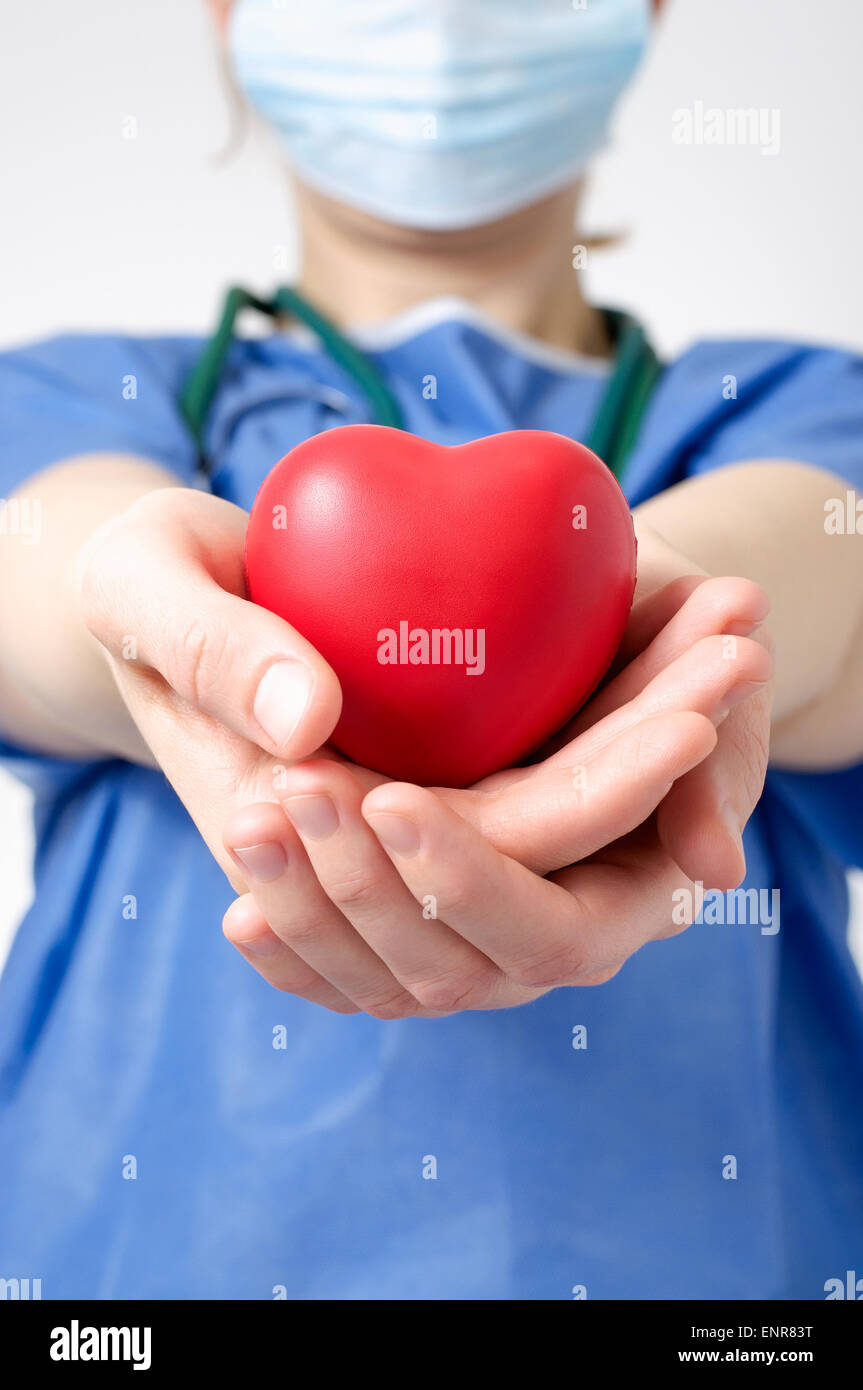 Médecin femme tenant une forme de coeur rouge Banque D'Images Médecin femme tenant une forme de coeur rouge Banque D'Images