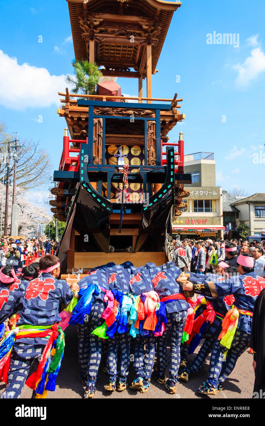 Équipe d'hommes luttant pour pousser un dashi massif, yama, float en bois, entouré de foules de touristes regardant au festival de printemps Inuyama Banque D'Images