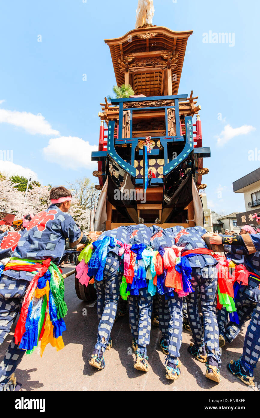 Équipe d'hommes luttant pour pousser un dashi massif, yama, float en bois, entouré de foules de touristes regardant au festival de printemps Inuyama Banque D'Images