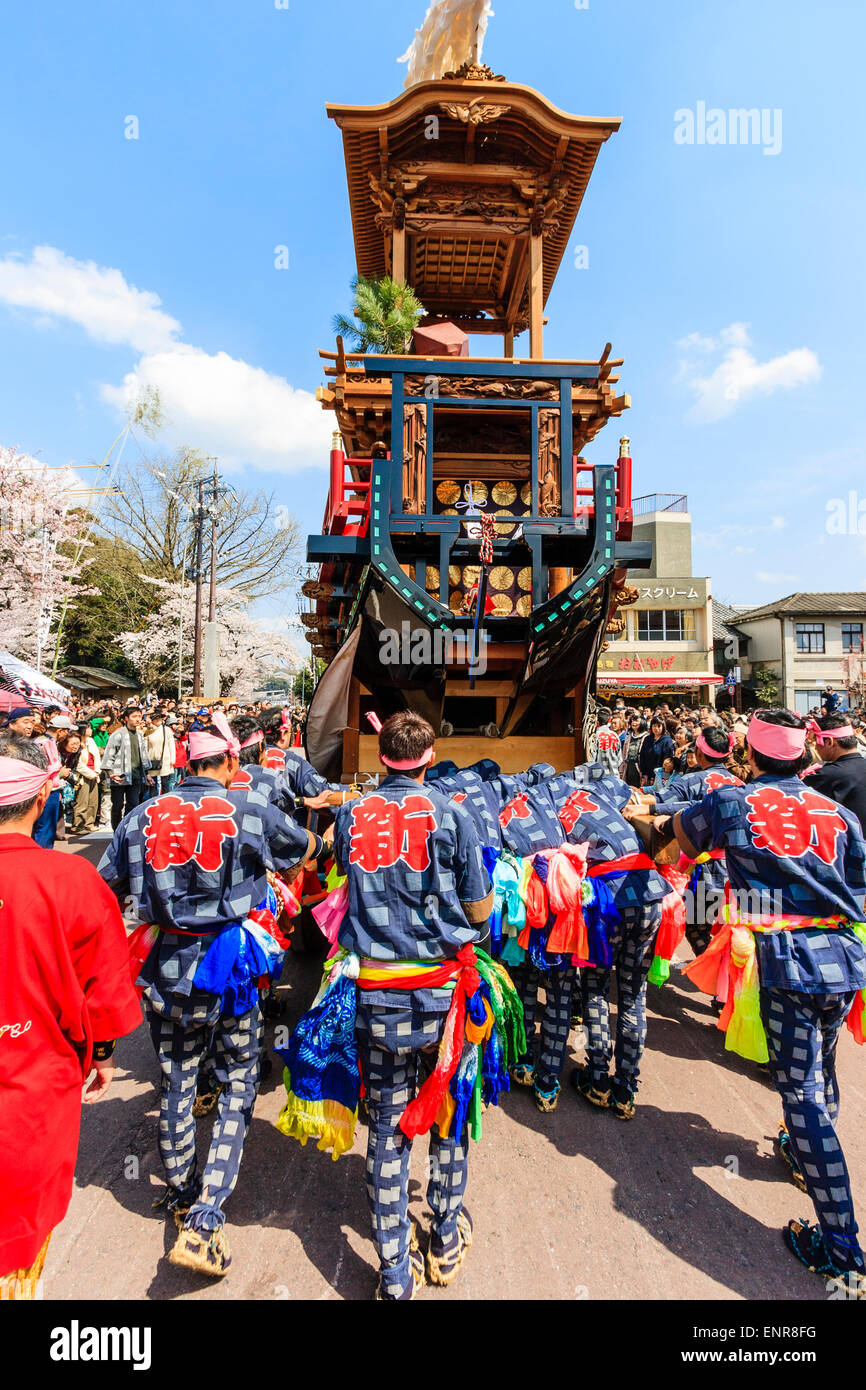 Équipe d'hommes luttant pour pousser un dashi massif, yama, float en bois, entouré de foules de touristes regardant au festival de printemps Inuyama Banque D'Images