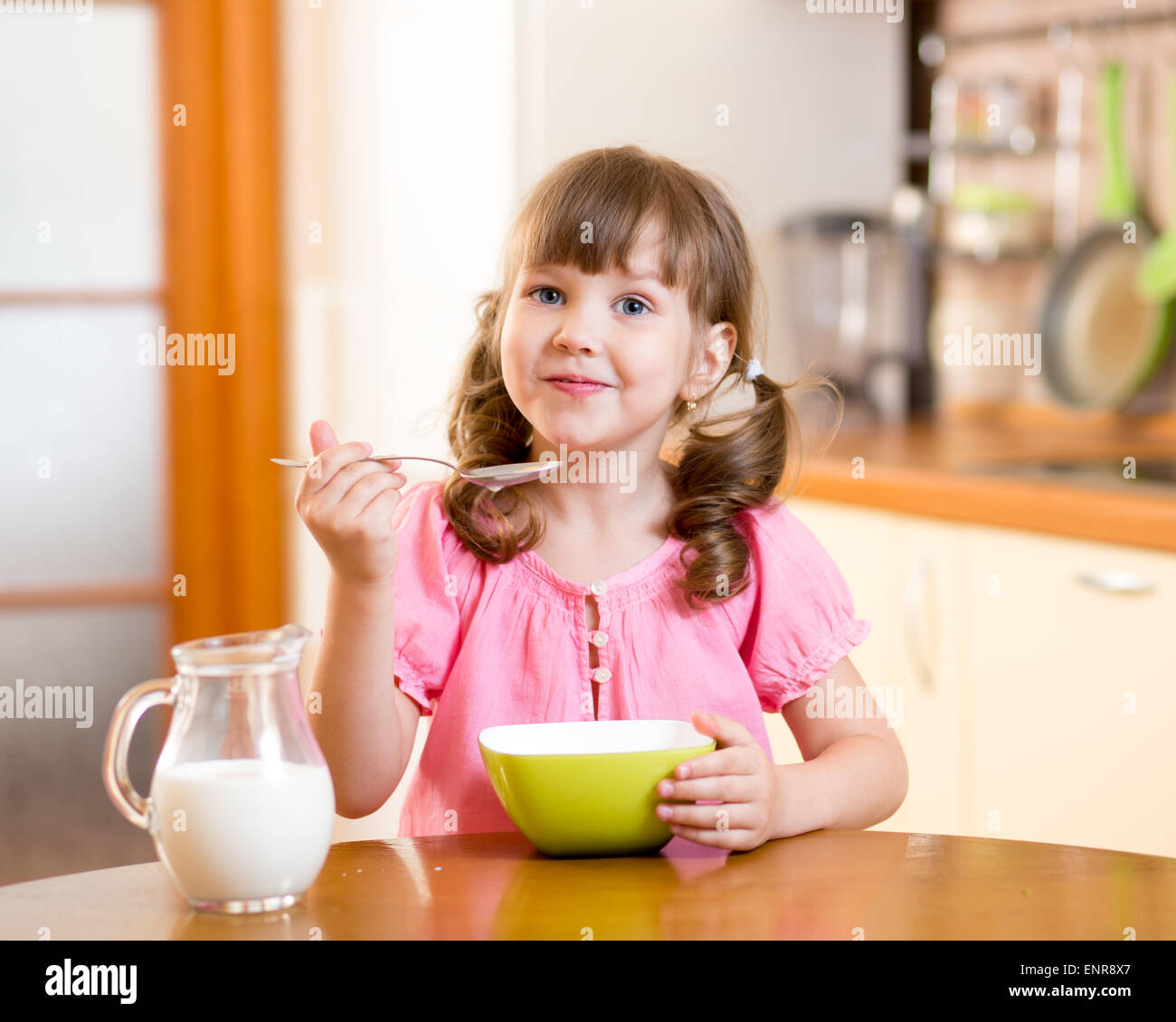 Kid girl eating healthy food in kitchen Banque D'Images