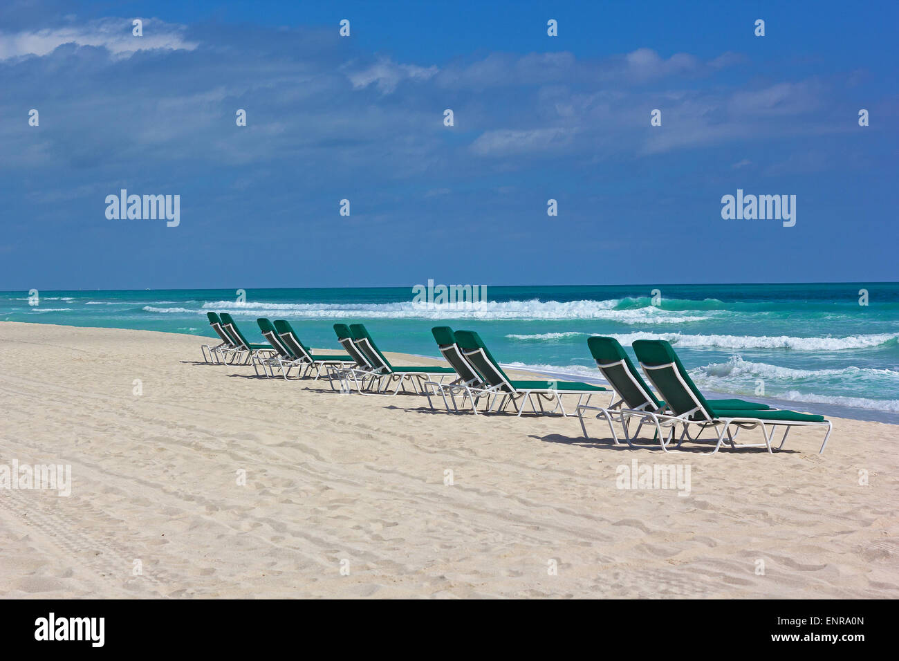 Miami Beach au printemps avec des vagues et des chaises de plage vide. Banque D'Images