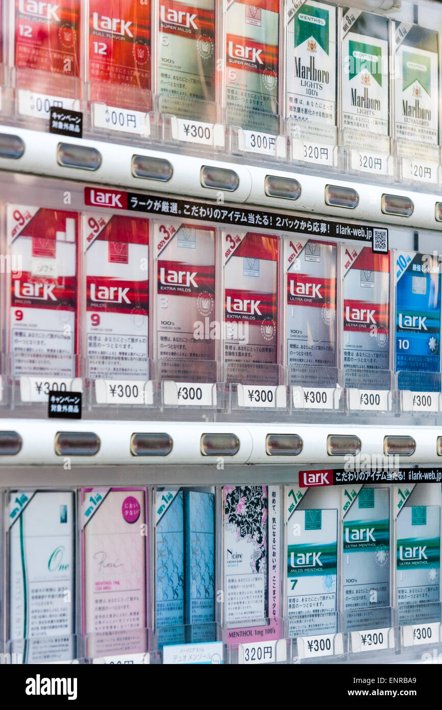 Gros plan de trois rangées de paquets de cigarettes, Lark et Marlboro, empilés dans un distributeur automatique au Japon. Banque D'Images