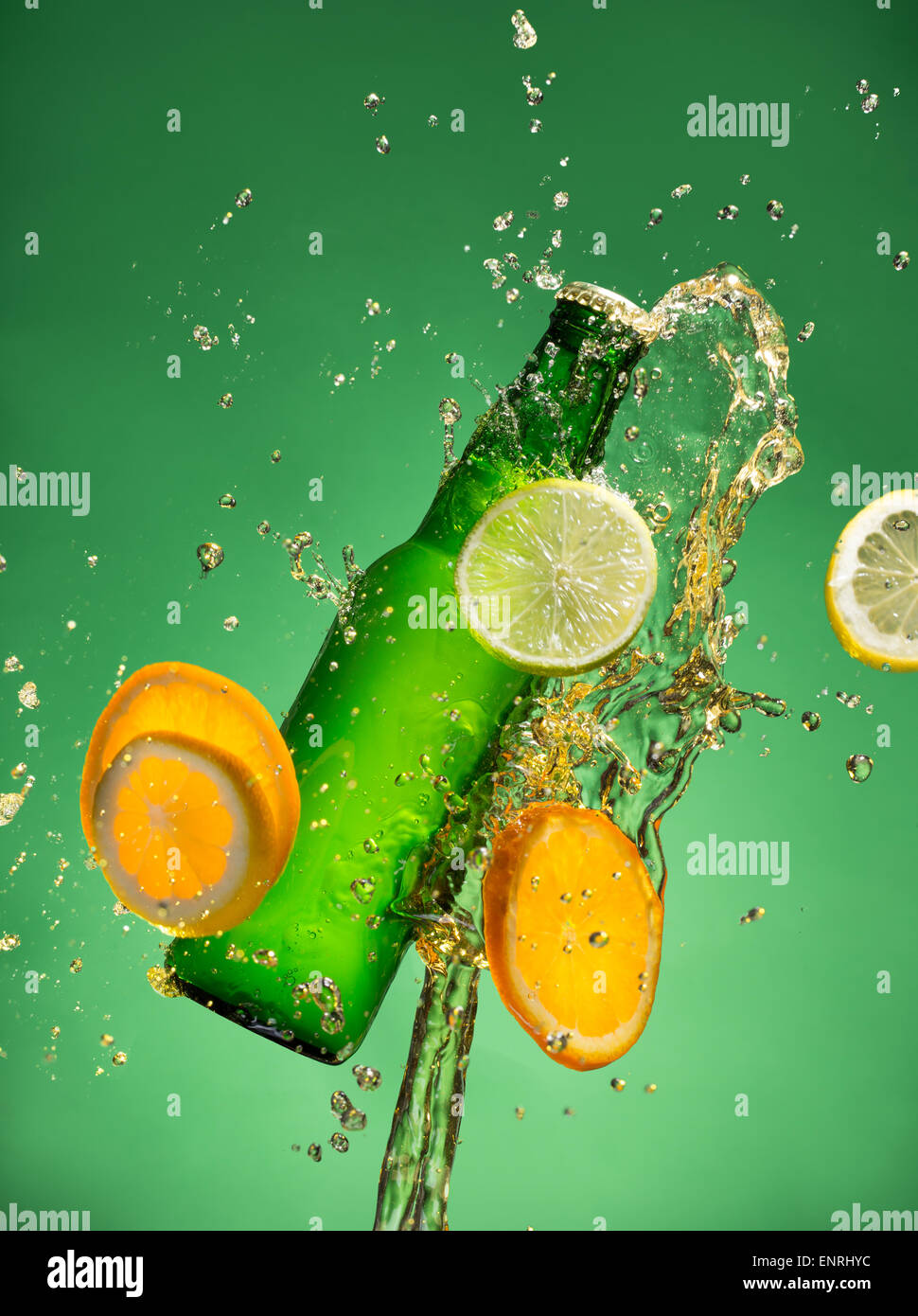 Bouteille de bière de fruits avec splash autour sur fond vert. Banque D'Images