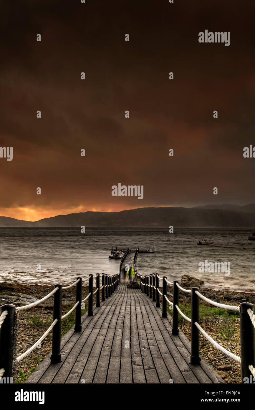 Approche de l'orage sur la côte Gruline, Ile de Mull, en Ecosse, avec des vents de 50 à 60 mph prévisions et deux hommes en train d'accumuler la jetée, Banque D'Images