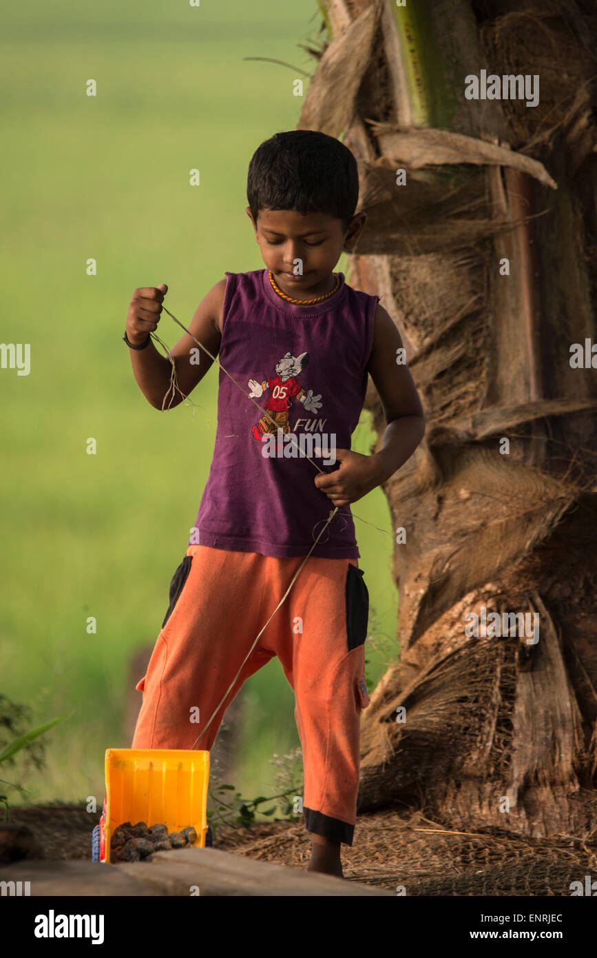 Un jeune garçon indien jouant avec son camion à jouets chez lui dans les eaux du Kerala en Inde Banque D'Images