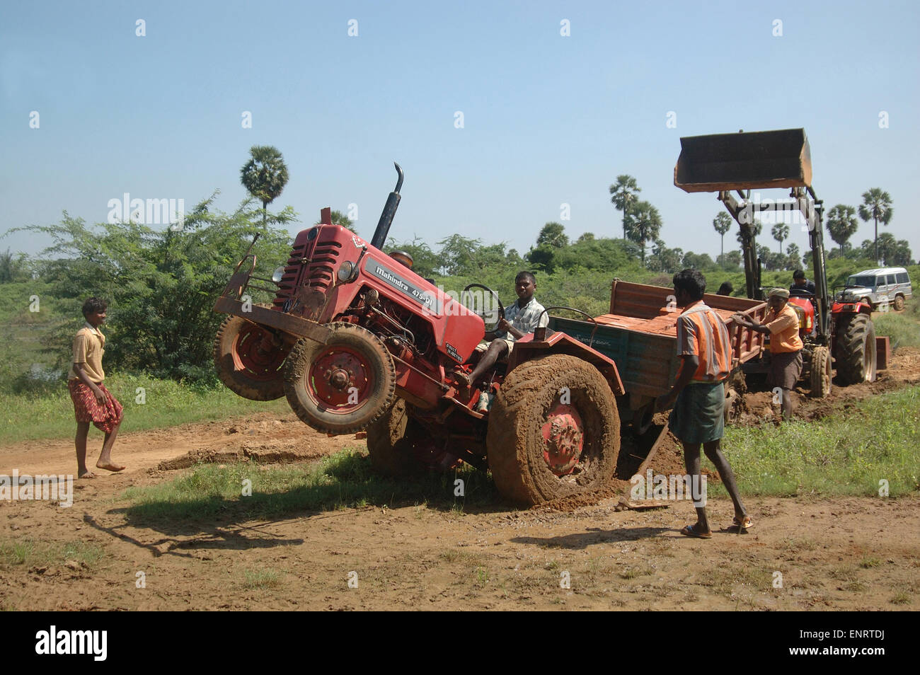 TAMIL Nadu, Inde, circa 2009 : hommes non identifiés pour travailler gratuitement un tracteur embourbé avec un chargement de briques dans la remorque, Banque D'Images