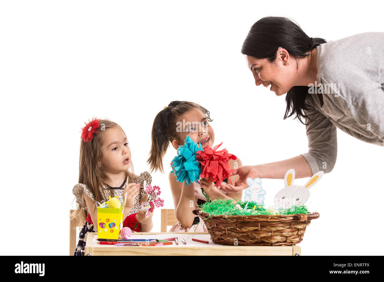 Mère parle avec sa fille qui la peinture des œufs de Pâques à table Banque D'Images