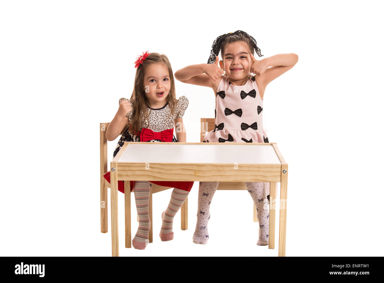 Deux jeunes filles faire des grimaces et des gestes ensemble isolé sur fond blanc Banque D'Images