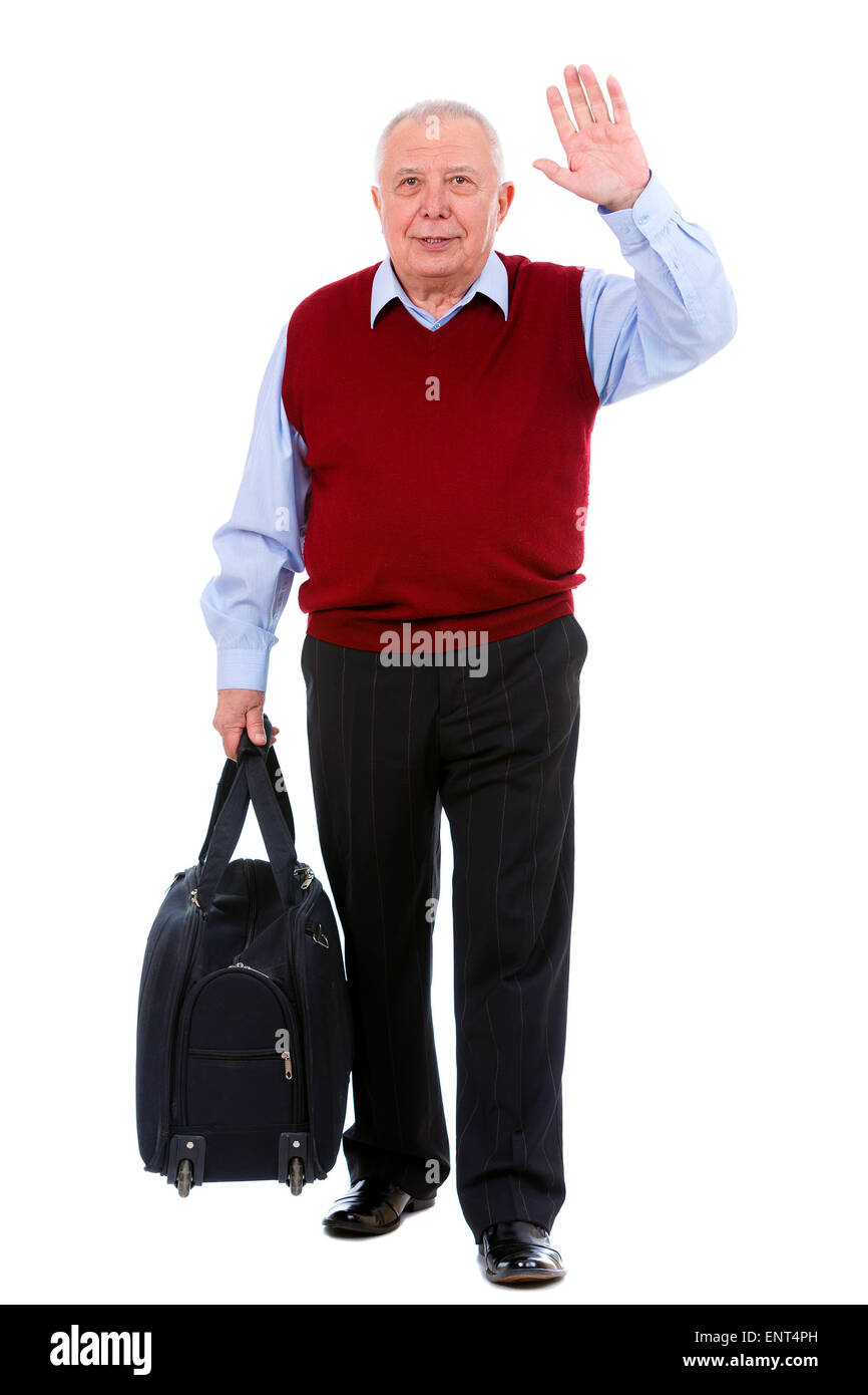 Ancien senior man holding une valise et en agitant sa main, isolé sur fond blanc Banque D'Images
