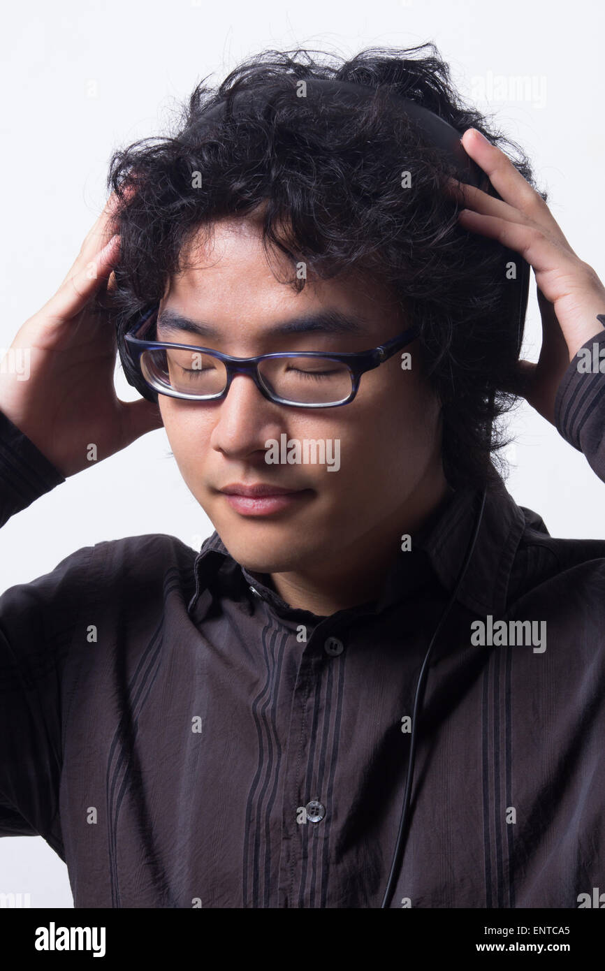 Asian young man wearing head directe avec les yeux fermés Banque D'Images