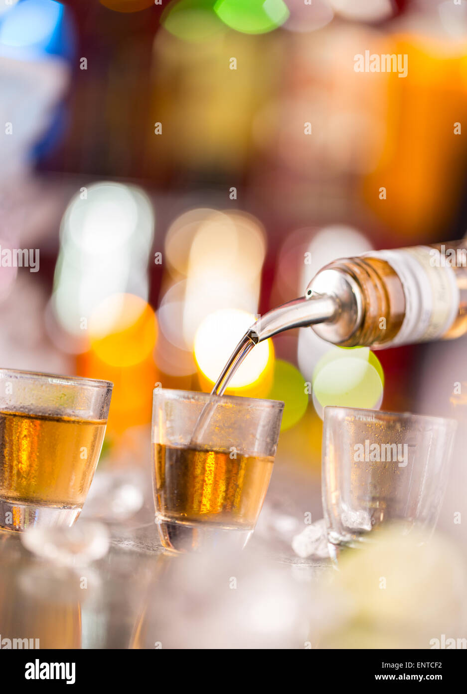 Barman pouring esprit dur dans des verres en détail Banque D'Images