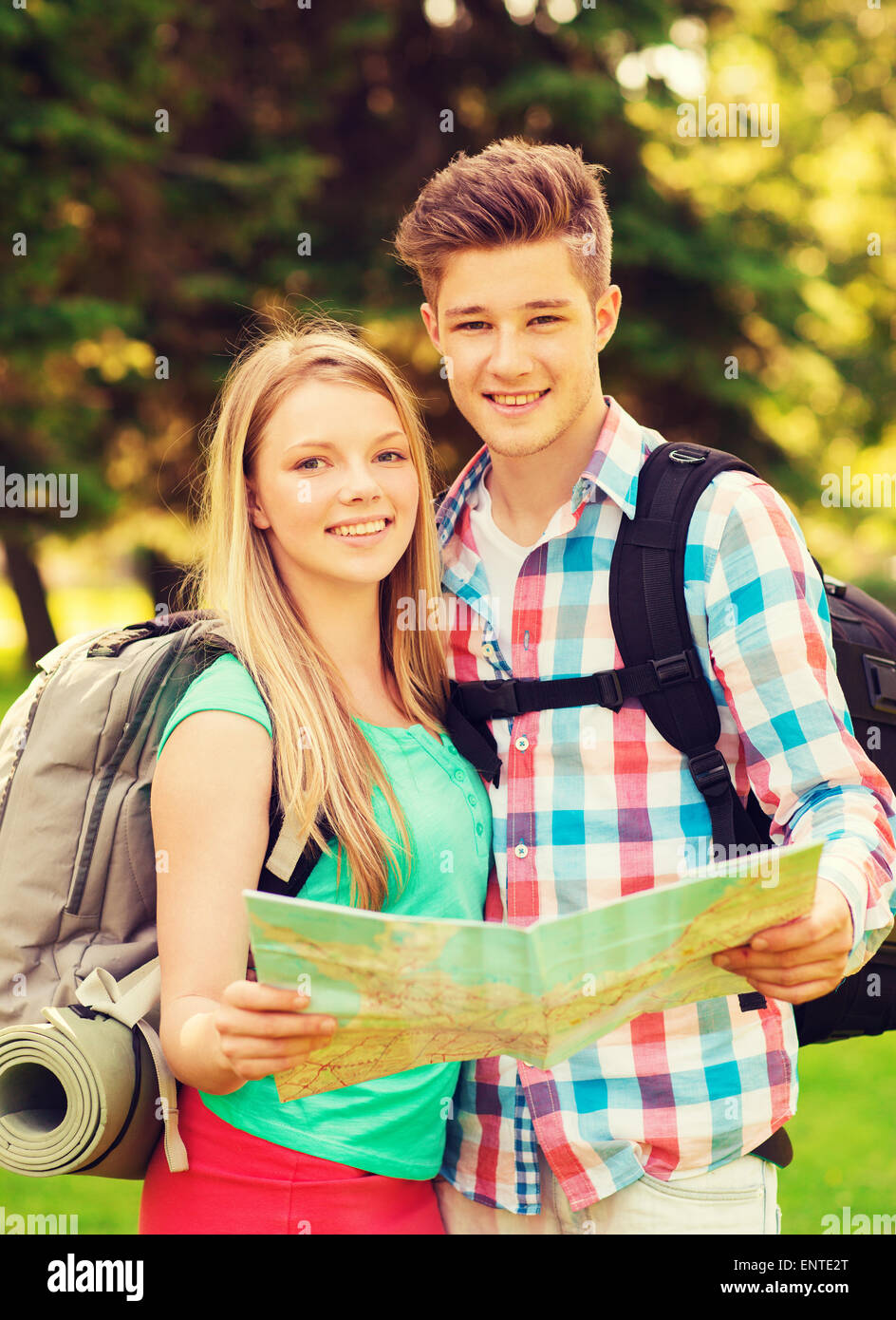Smiling couple with map et son sac à dos dans la forêt Banque D'Images