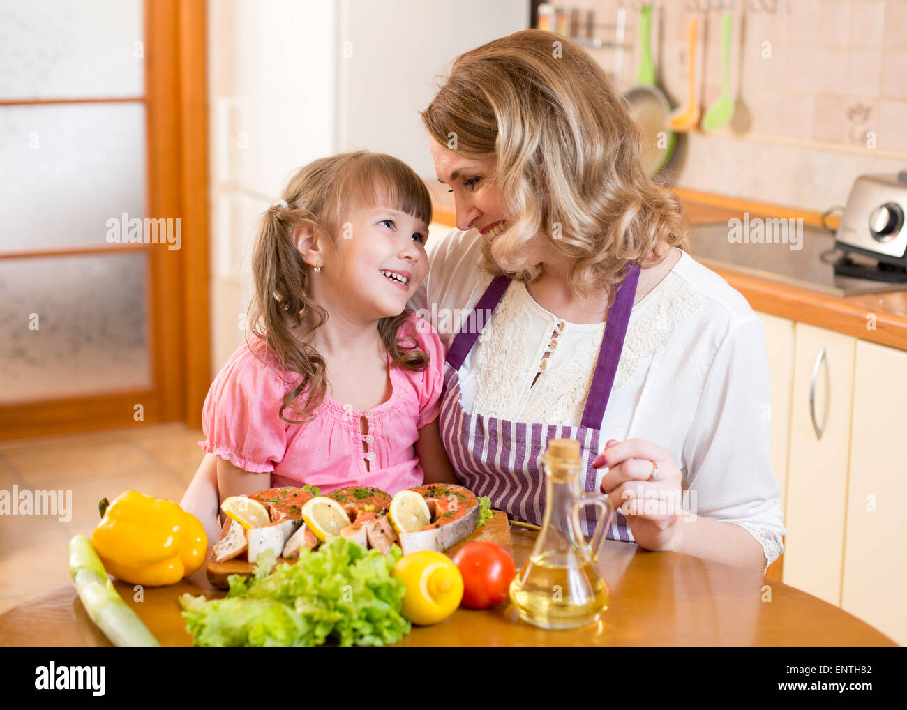 Mère et fille cook et communiquer dans la cuisine à la maison Banque D'Images