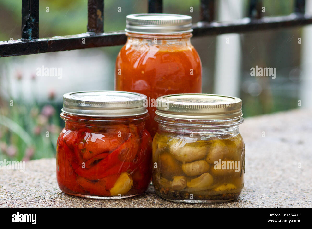 Trois pots de conserves de légumes sur le patio extérieur. Banque D'Images