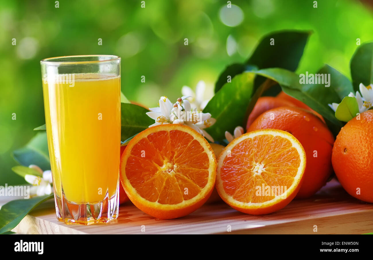 Le jus d'Orange dans le verre, fleurs et fruits tranche d'orange. Banque D'Images