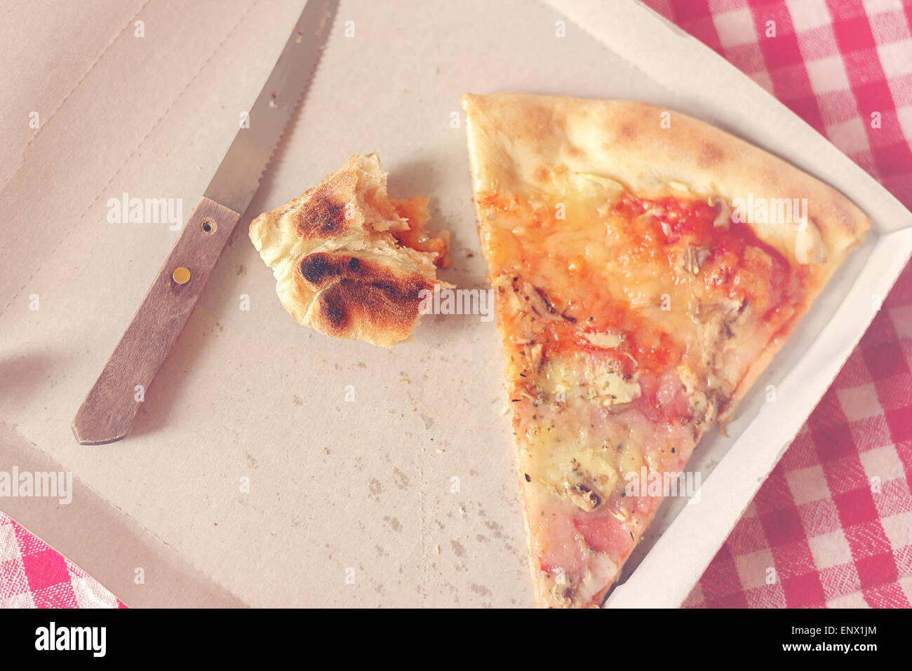 Pizza Slice et Fast Food les restes dans la boîte de carton sur la table de cuisine, Style Retro Droit Tonique Banque D'Images