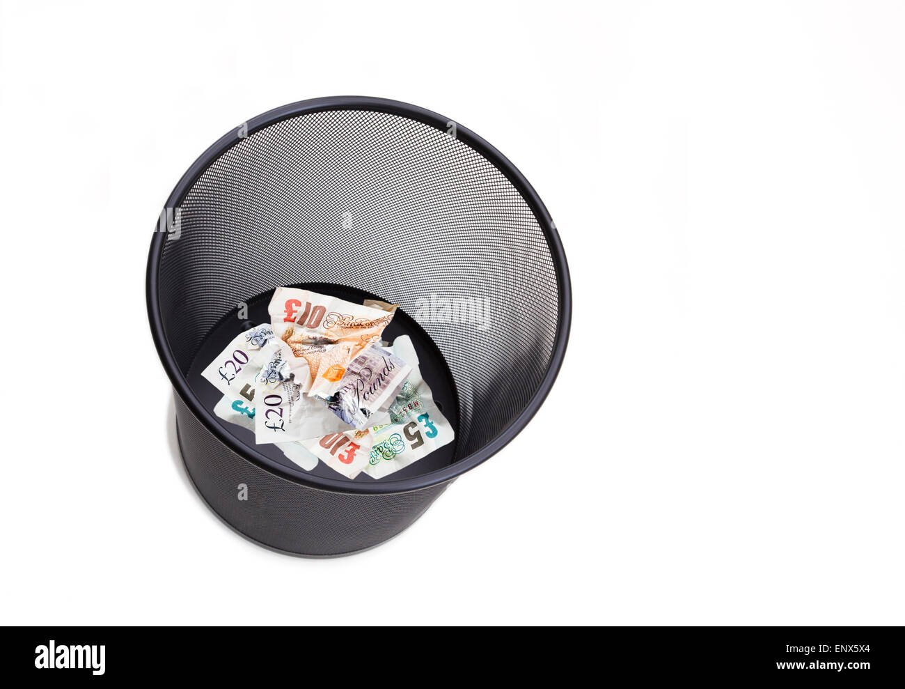 L'argent sterling pound note livres vissés et jetées dans un bac à papier blanc pour illustrer le concept de l'argent gaspillé. England UK Banque D'Images