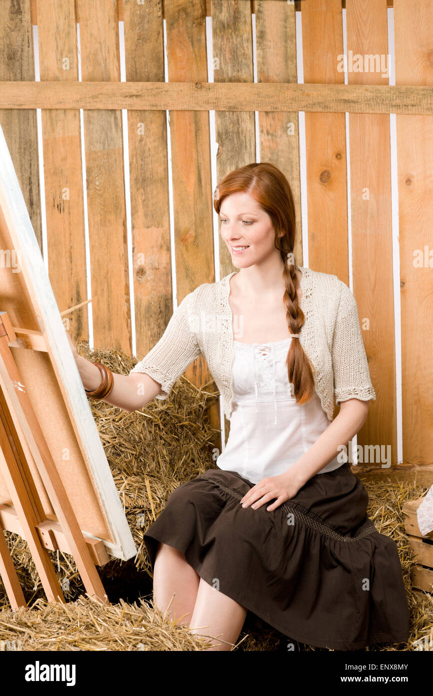 Red-hair romantic woman in barn pays peinture Banque D'Images