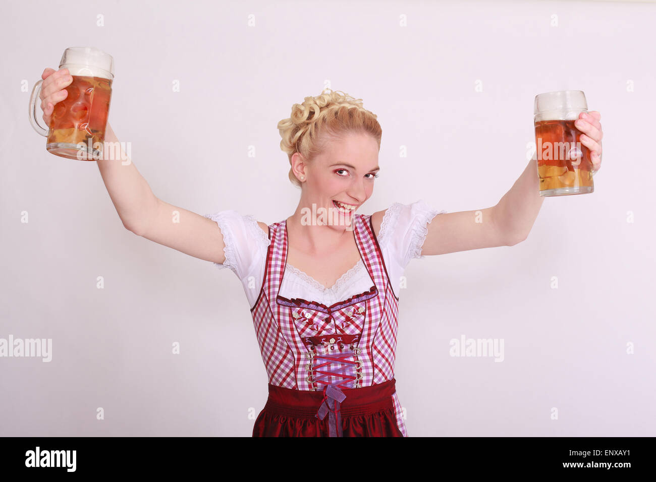 Jeune femme dans la dirndl plein de deux chopes de bière Banque D'Images