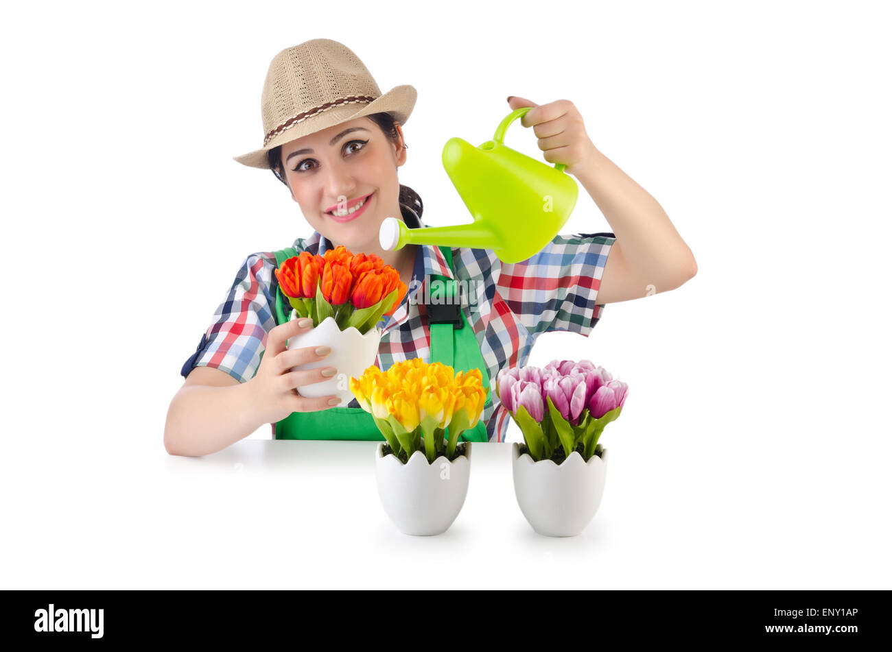 Girl watering plants on white Banque D'Images