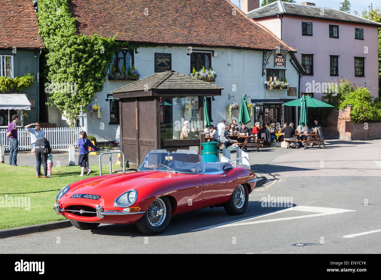Un rouge E-Type Jaguar sur Finchingfield village vert à l'extérieur de la Fox Inn, Finchingfield, Essex, Angleterre, RU Banque D'Images
