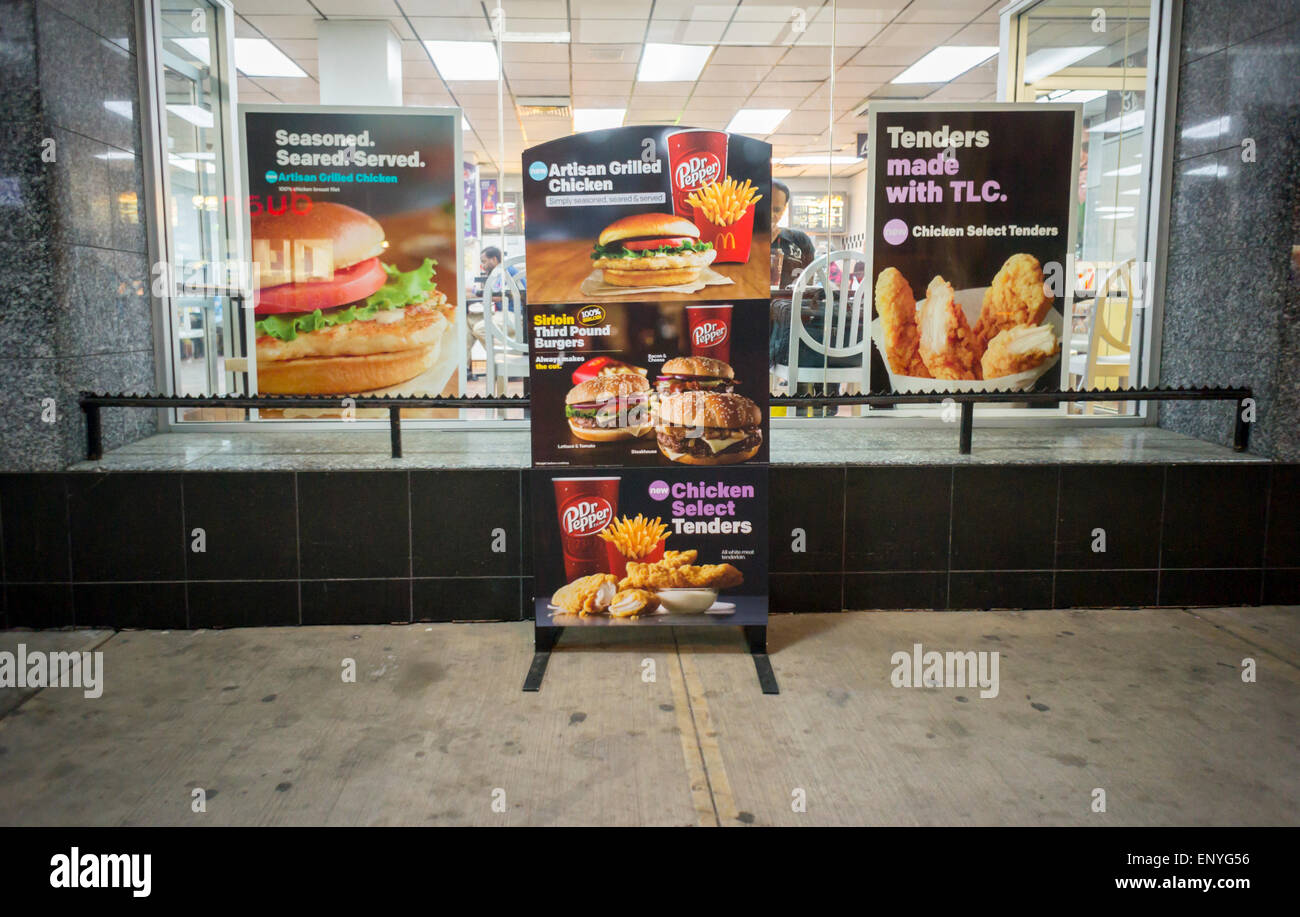 Les affiches publicitaires à l'extérieur d'un restaurant McDonald's à New York le mardi, Mai 5, 2015 promouvoir leurs nouvelles offres y compris un sandwich au poulet grillé artisanale. La McDonald's Corp. a annoncé sa stratégie de redressement qui comprend aujourd'hui 3500 magasins de franchise de l'entreprise et la restructuration de l'entreprise en quatre unités basées sur les ressemblances plutôt que d'emplacements géographiques. (© Richard B. Levine) Banque D'Images