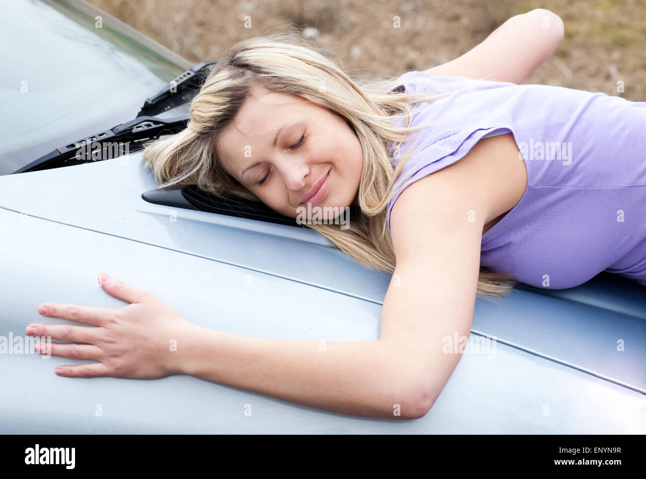 Cheerful conductrice huging sa nouvelle voiture Banque D'Images