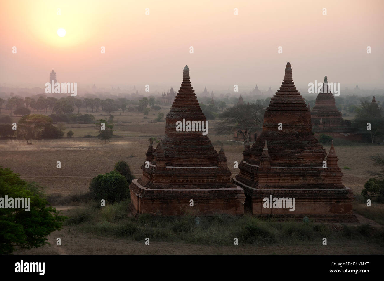 Les silhouettes sombres des temples contre le ciel rougeoyant jaune au lever de Bagan Myanmar Banque D'Images