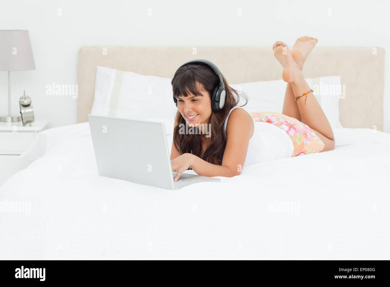 Jeune femme sur un ordinateur portable avec des écouteurs Banque D'Images Jeune femme sur un ordinateur portable avec des écouteurs Banque D'Images