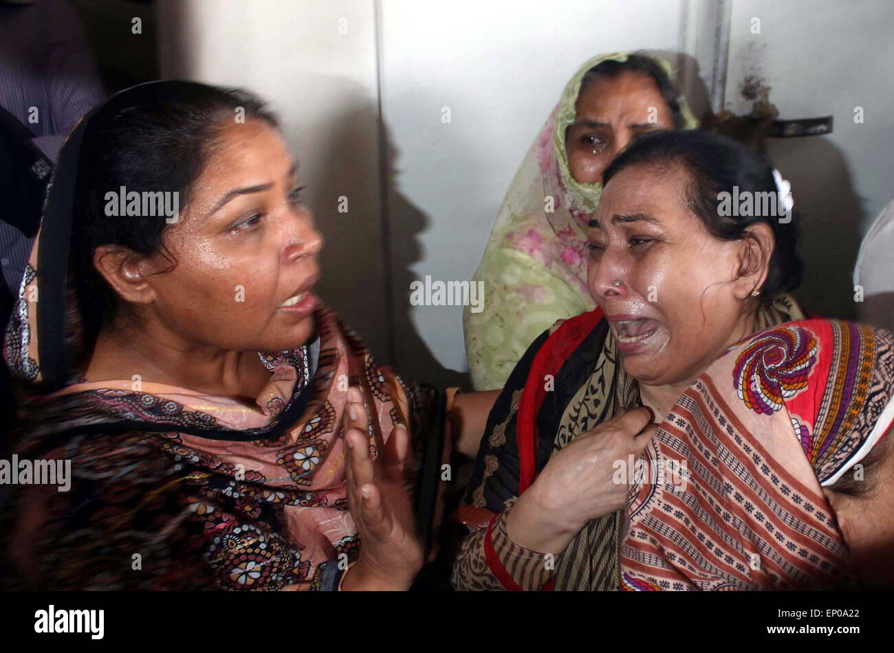 Karachi, Pakistan. 12 mai, 2015. Des proches de l'ancien Muttahida Qaumi Movement (MQM) Activiste Saulat Mirza réagir pleurer sur le déplacement de son corps, qui a été pendu à la prison de Mach, mardi, dans une affaire de meurtre triple a été dit d'être calme et composé à l'échafaud, à l'Aéroport International Jinnah Muttahida Qaumi Movement dans Ancien (MQM) Activiste Saulat Mirza a été exécuté aujourd'hui matin à 4 h 30, de l'assassinat de l'ancien directeur général de la société KESC Shahid Hamid, son chauffeur et garde côtière canadienne en 1997. Banque D'Images