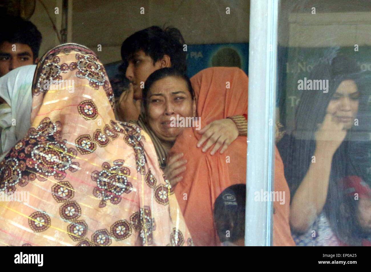 Karachi, Pakistan. 12 mai, 2015. Des proches de l'ancien Muttahida Qaumi Movement (MQM) Activiste Saulat Mirza réagir pleurer sur le déplacement de son corps, qui a été pendu à la prison de Mach, mardi, dans une affaire de meurtre triple a été dit d'être calme et composé à l'échafaud, à l'Aéroport International Jinnah Muttahida Qaumi Movement dans Ancien (MQM) Activiste Saulat Mirza a été exécuté aujourd'hui matin à 4 h 30, de l'assassinat de l'ancien directeur général de la société KESC Shahid Hamid, son chauffeur et garde côtière canadienne en 1997. Banque D'Images