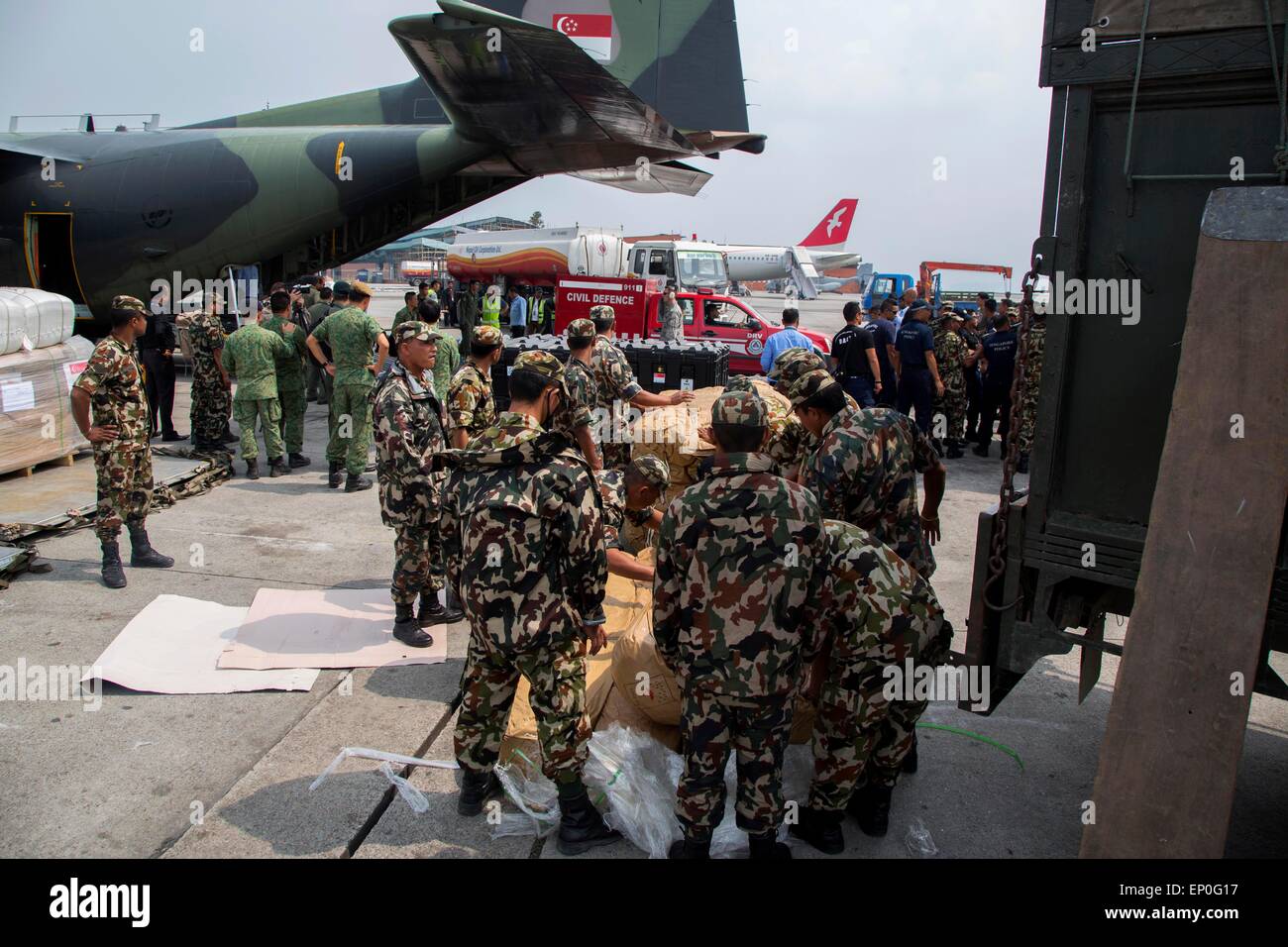 Katmandou, Népal. 10 mai, 2015. Des soldats népalais et singapouriens se décharger des approvisionnements de secours à l'aéroport international de Tribhuvan suite à des tremblements de terre qui ont frappé le royaume des montagnes, le 9 mai 2014 à Katmandou, au Népal. Banque D'Images