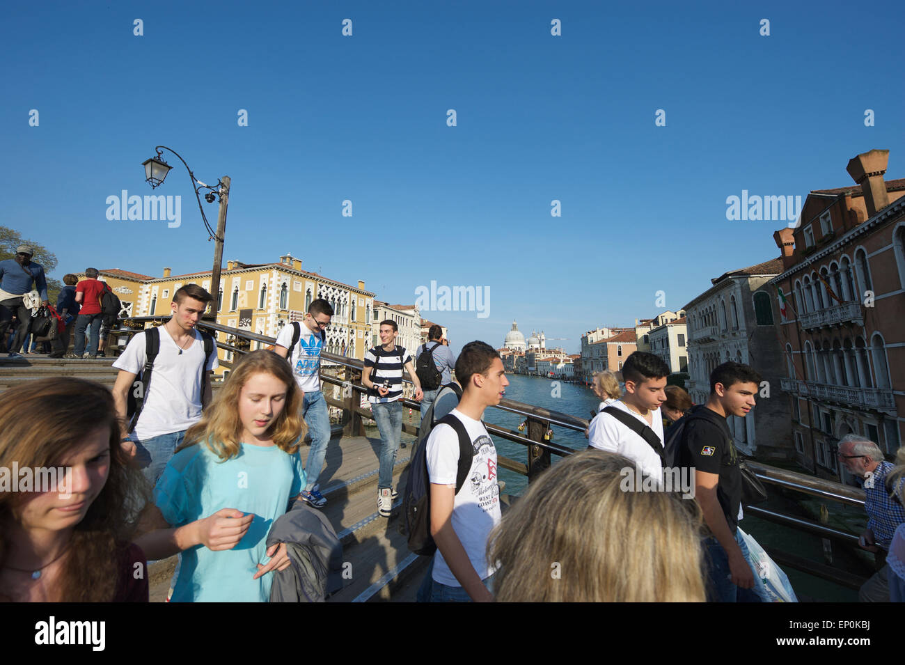 Venise, Italie - 24 avril 2013 : des foules de touristes passent le long du pont de l'Académie contre un pont sur le Grand Canal. Banque D'Images