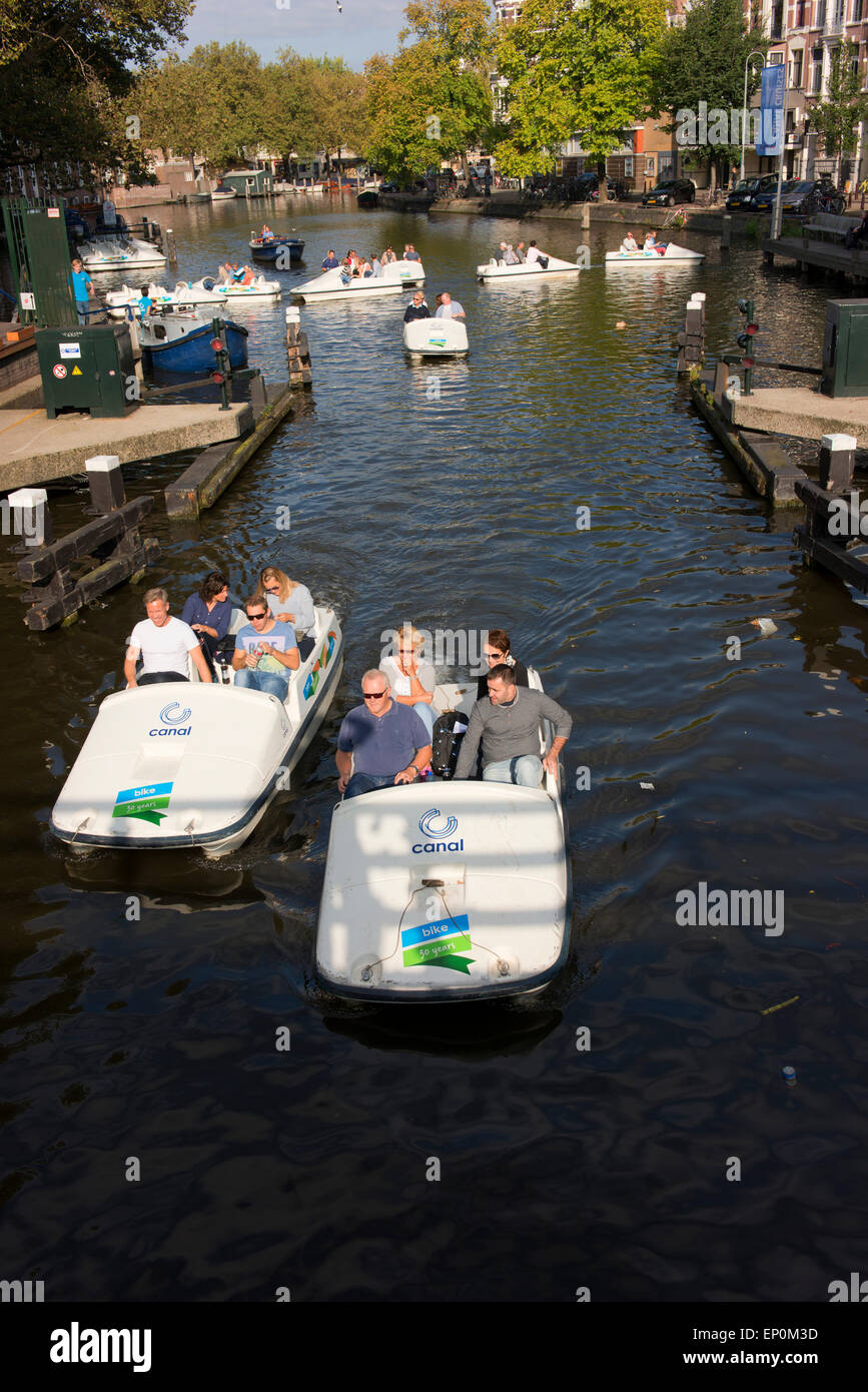 Les touristes s'amuser dans des bateaux sur un canal dans le centre d'Amsterdam. Banque D'Images